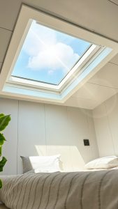 Sonnenlicht fällt durch ein Dachfenster ins Dachgeschoss – Sommerhitze unterm Dach