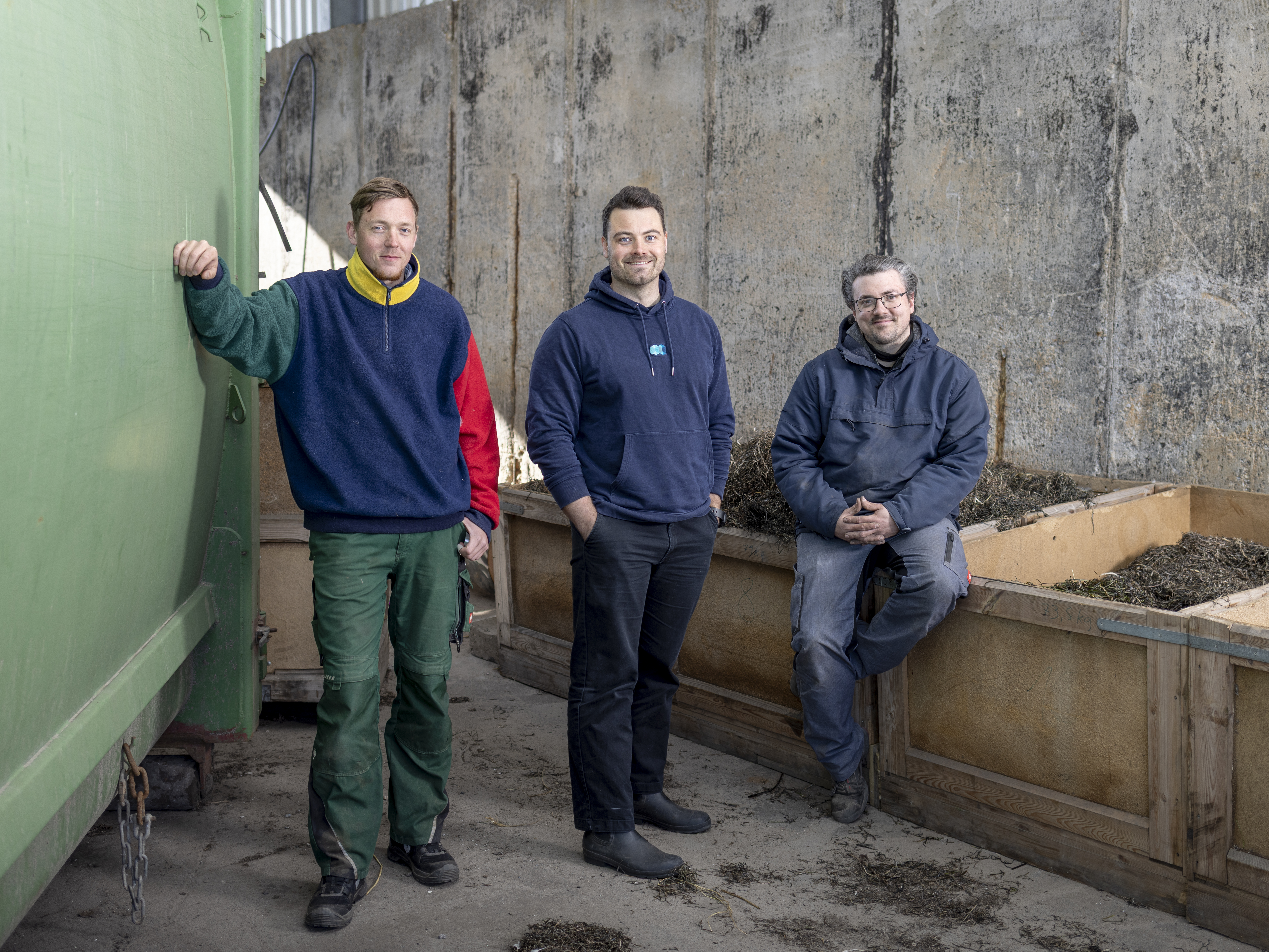 Drei Build-Blue-Mitarbeiter stehen im Hof der Produktionshalle auf Poel